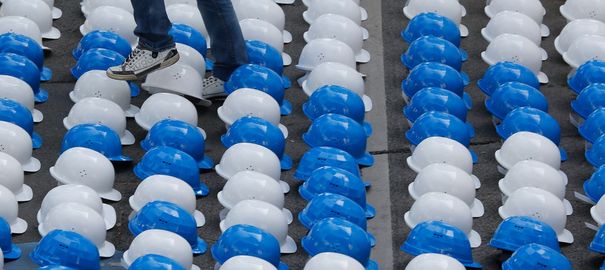 Des casques d'ouvriers sont disposés sur le sol en mémoire des travailleurs étrangers tués sur les chantiers du Mondial 2022.